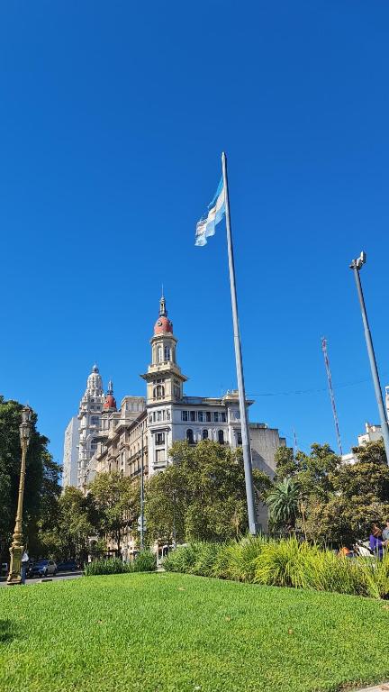 a flag on a pole in front of a building at Habitación privada, solo Damas "Alma de mujer" in Buenos Aires
