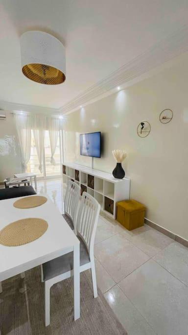 een woonkamer met een witte tafel en stoelen bij F3 Chic et Cosy très accessible in Dakar