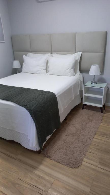 um quarto com uma grande cama branca e um cobertor preto em Studio Praia do Jardim 1 305B em Angra dos Reis
