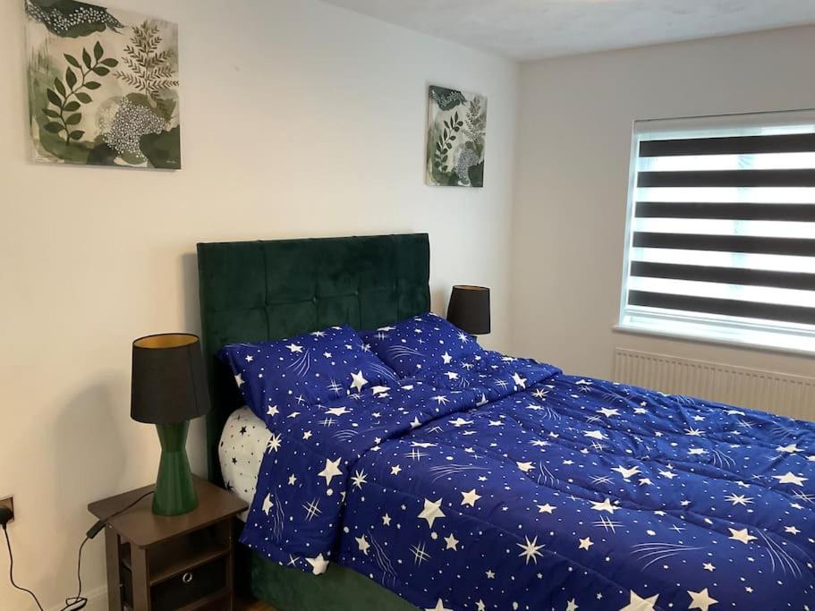 sypialnia z łóżkiem z niebieską kołdrą z gwiazdami w obiekcie Exclusive 3 Bed Home-5 mins from Lakeside Shopping Mall w mieście West Thurrock