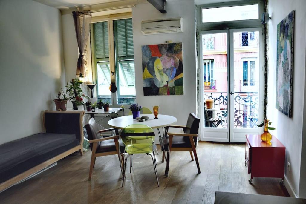 sala de estar con mesa, sillas y ventanas en Nice - Stylish apartment downtown, en Niza