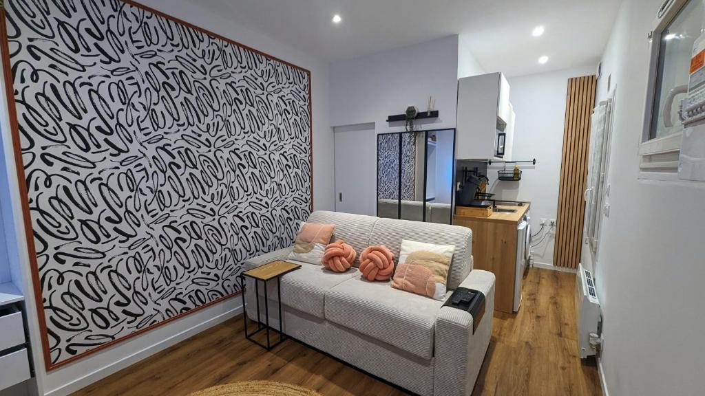 sala de estar con sofá y una gran pintura en Le Charme Rosé, en Villejuif