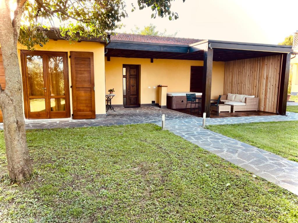 a yellow house with a patio and a yard at Casa i Limori in San Giuliano Terme