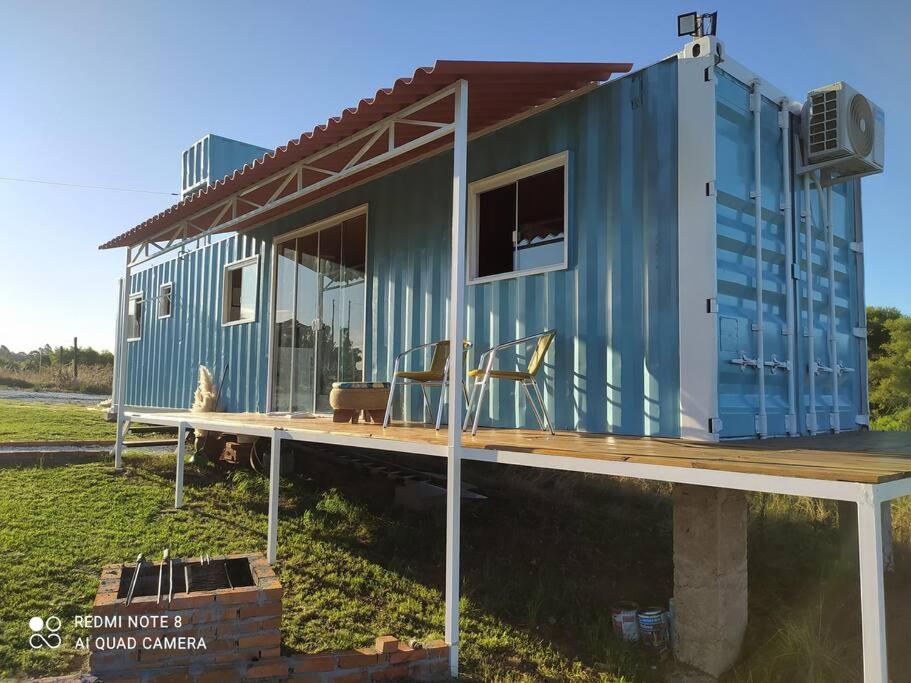 a blue tiny house sitting on top of a wooden deck at Casa Container Azul. in Bagé