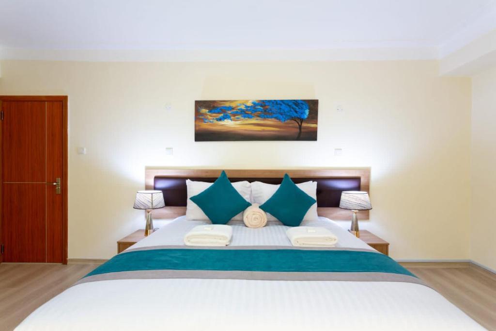 a bedroom with a large bed with blue pillows at Amber suites in Nairobi
