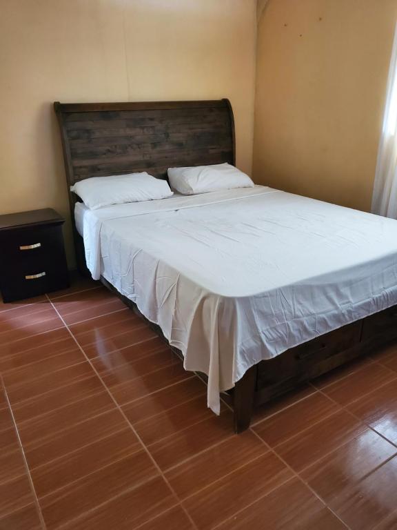 a bedroom with a large bed with white sheets at Lind's comfort place in Roseau