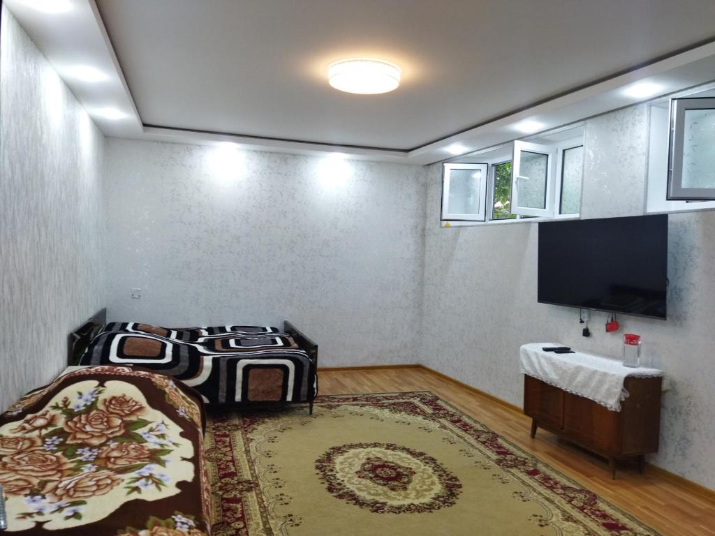 a bedroom with a bed and a flat screen tv at Tatil evi in Sheki
