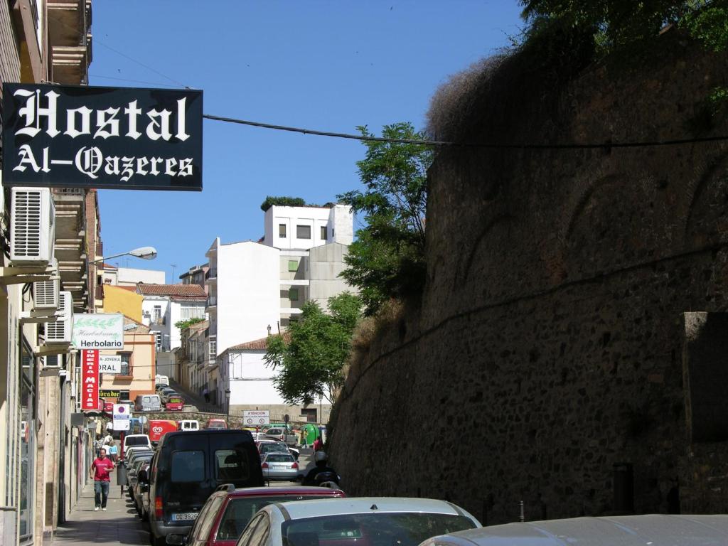 uma movimentada rua da cidade com carros estacionados na rua em Hostal Al-Qazeres em Cáceres