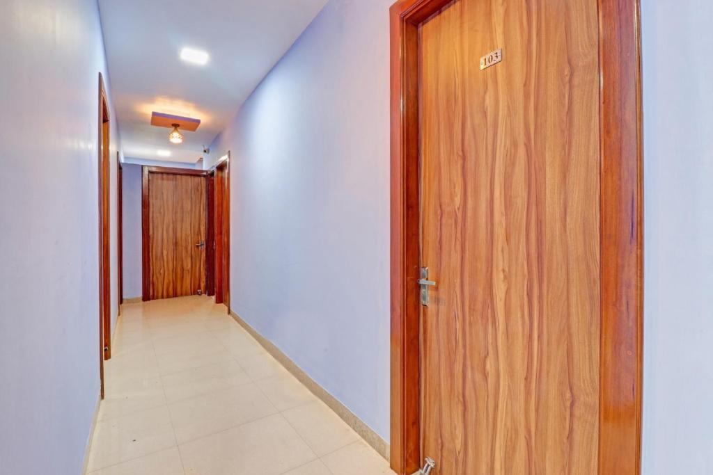 pasillo con puerta de madera y suelo de baldosa en OYO Hotel Four S, en Haridwar