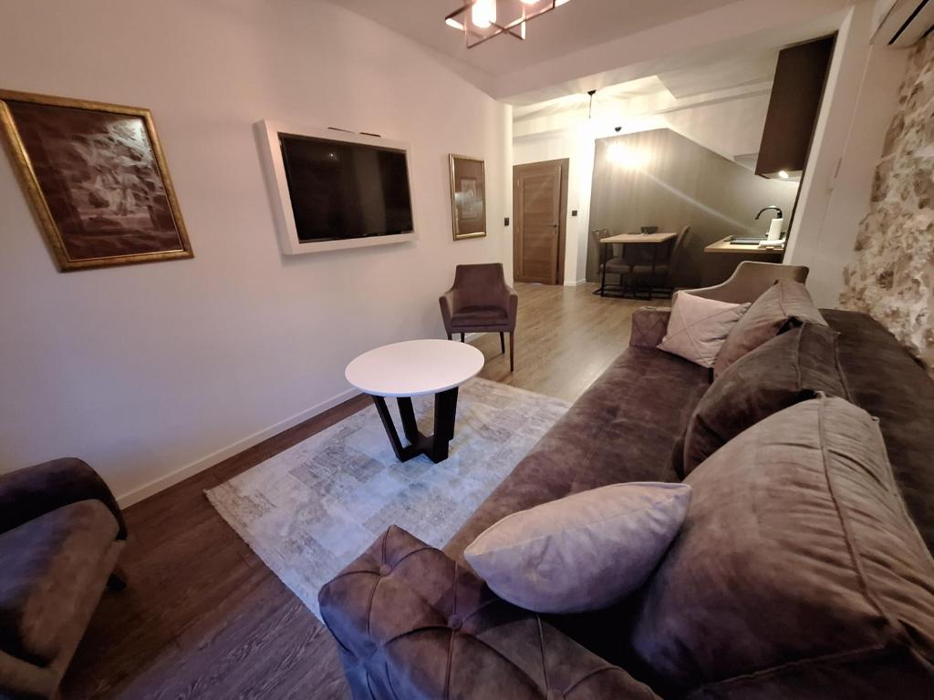 Apartmani Fantasia Cetinje في ستنيي: غرفة معيشة مع أريكة وطاولة