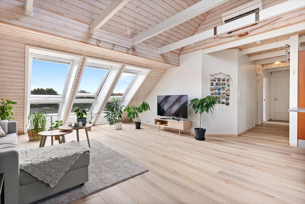 uma sala de estar com tectos em madeira e janelas grandes em Leilighet i Nærbø sentrum em Nærbø