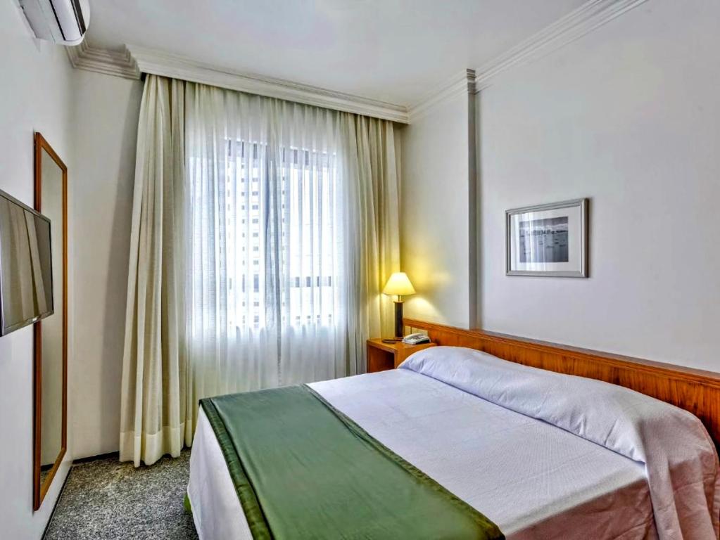 Premium Flats - Tulip Inn في فورتاليزا: غرفه فندقيه بسرير ونافذه