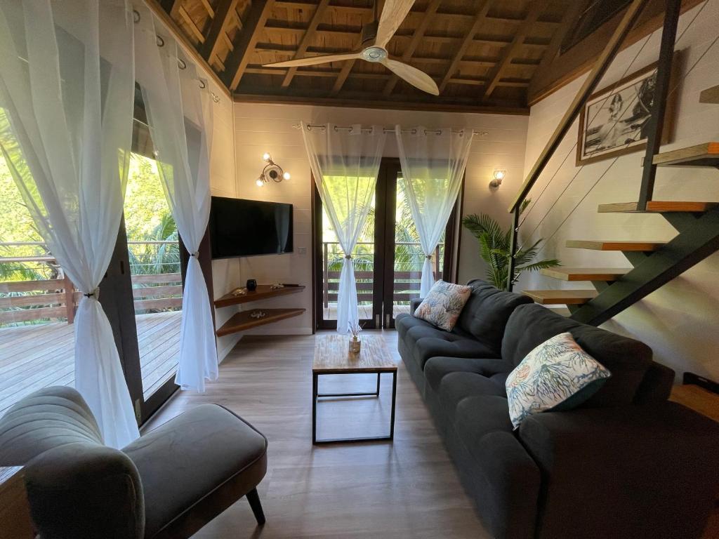ein Wohnzimmer mit einem Sofa und einem TV in der Unterkunft VILLA TAAROA LEGENDS in Haapiti
