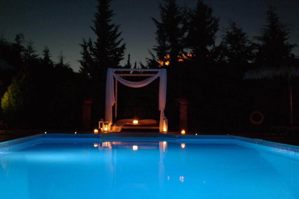 een groot zwembad 's nachts met verlichting in bij Elpiniki in Mithimna
