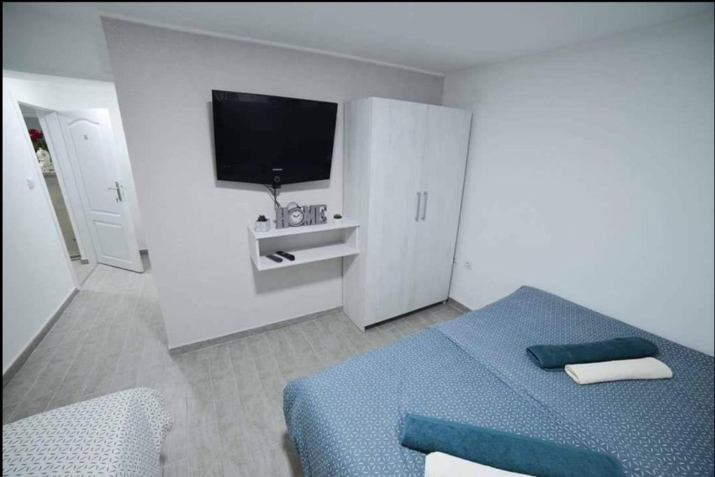 a bedroom with a bed and a tv on the wall at Hostel Tuzla in Tuzla