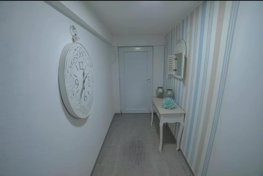 a hallway with a table and a clock on the wall at Hostel Tuzla in Tuzla