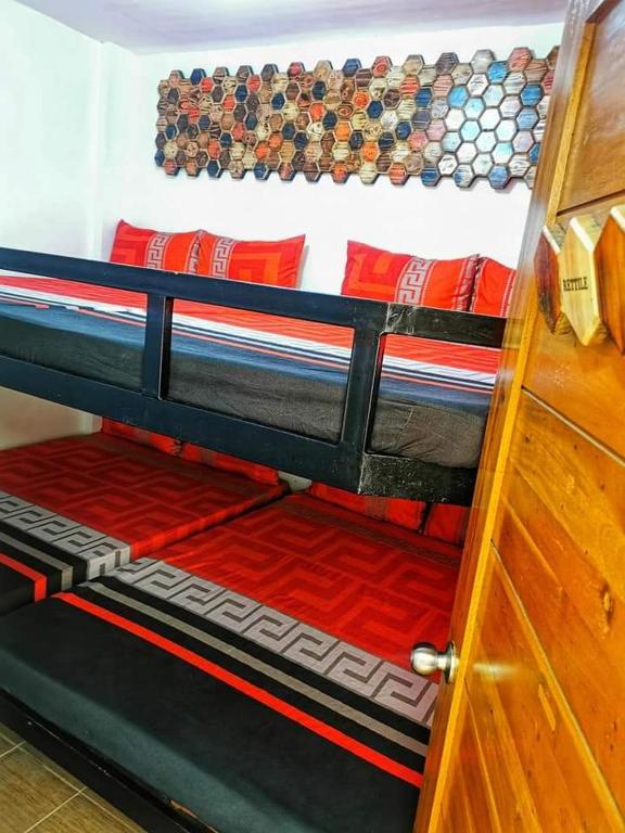 a bunk bed with red pillows and a wooden door at Aurum Hot Spring Resort in Los Baños