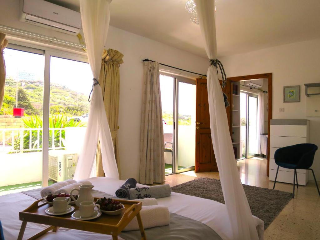 um quarto com uma cama com uma mesa e uma varanda em 3 Balconies South Views Special Bedroom 5 mins to beach em Mellieħa