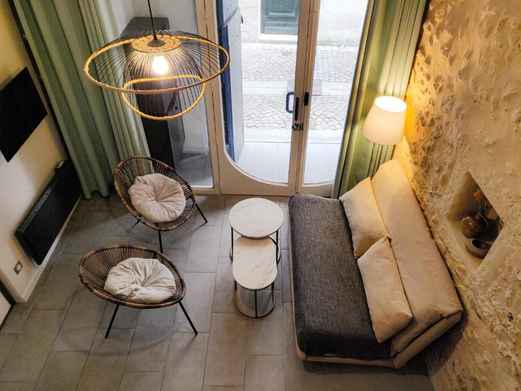 un salon avec un canapé, des chaises et une fenêtre dans l'établissement Appartement dans le centre historique, à Bordeaux