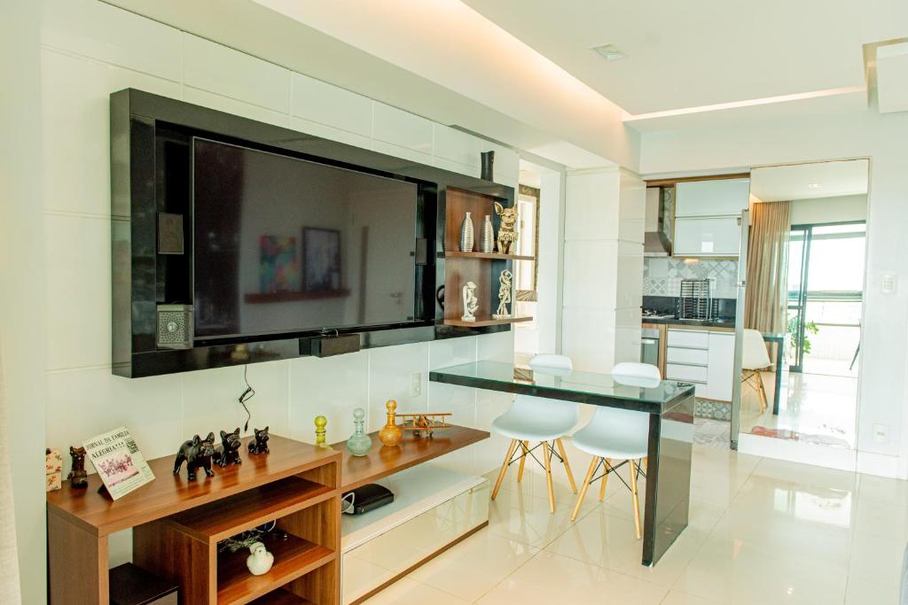 uma cozinha com uma mesa e uma televisão na parede em Apartamento de luxo em Salvador