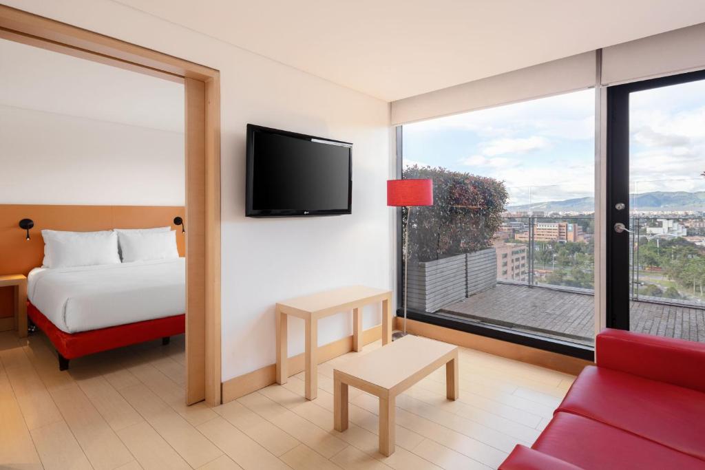 a hotel room with a bed and a large window at Fairfield by Marriott Bogota Embajada in Bogotá