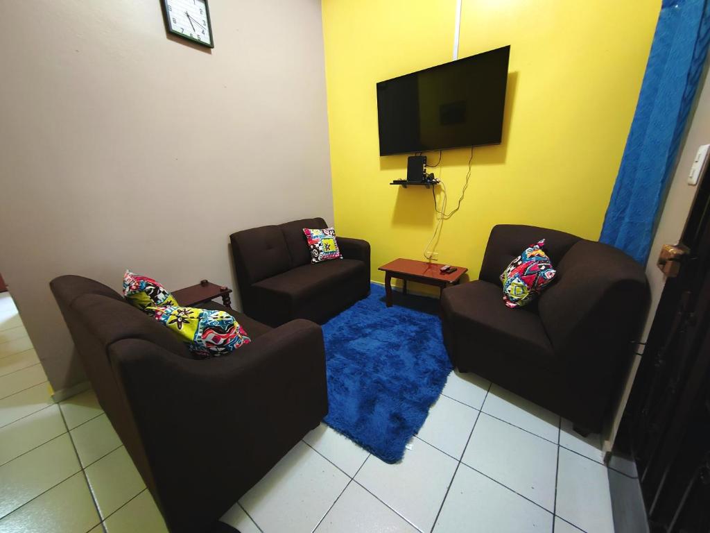 a living room with two chairs and a flat screen tv at La Campana in San Miguel