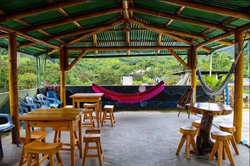 a pavilion with tables and chairs and a hammock at Hotel Anita in Mindo