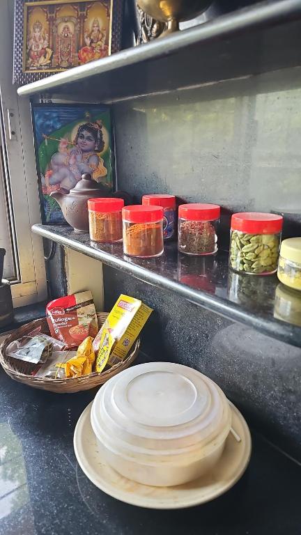 a counter with plates and other food items in a kitchen at Laxmi Happy Home in Pune in Pune