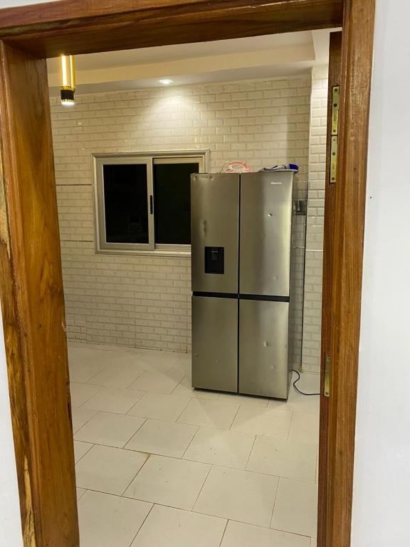 eine Küche mit einem Kühlschrank aus Edelstahl in einem Zimmer in der Unterkunft Villas meublé yoff in Dakar