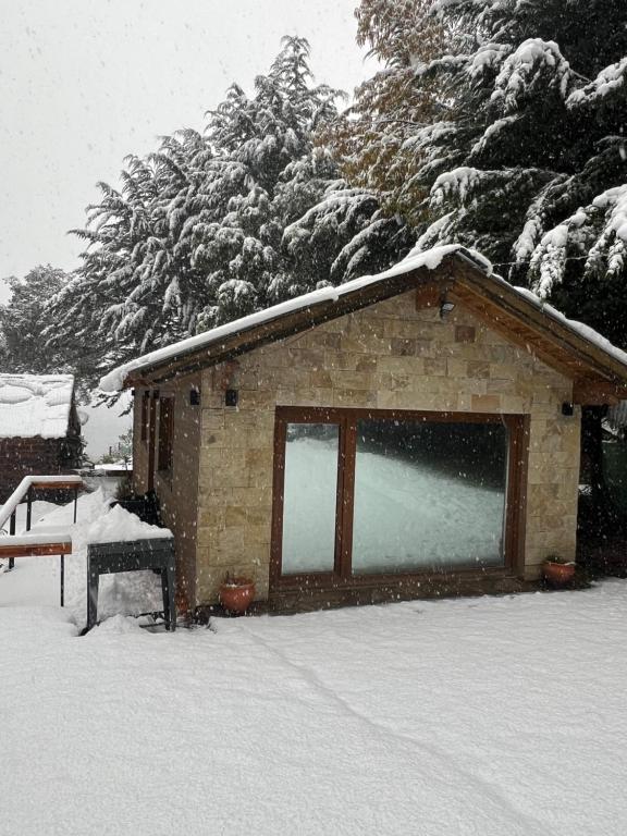 un petit bâtiment avec de la neige sur le toit dans l'établissement Casa con vista al lago, à San Carlos de Bariloche