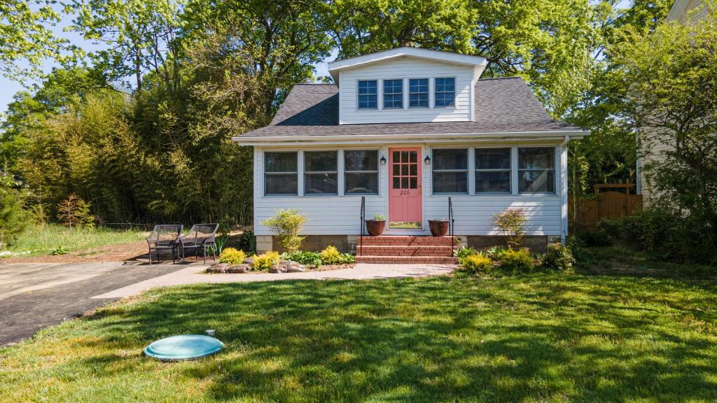 una casa bianca con una porta rossa e un frisbee nel cortile di Grandma's Summer House Beverly Beach a Edgewater