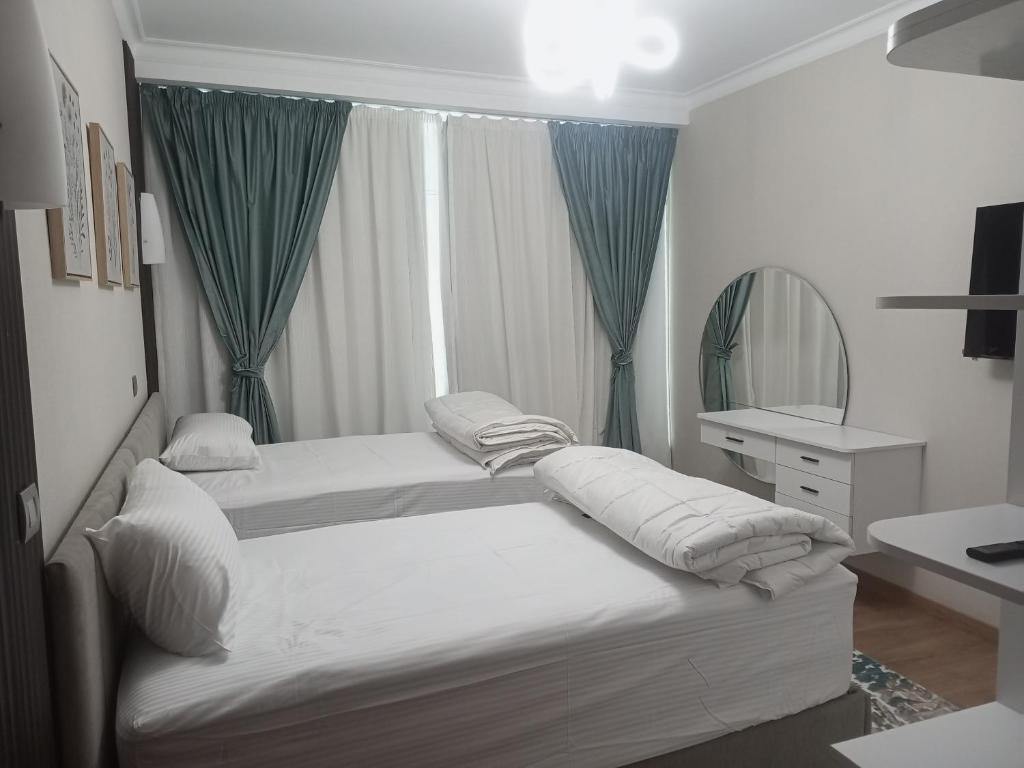 2 camas en una habitación con espejo y lavabo en شقة فندقية في فندق هيلتون المعادي علي الكورنيش مباشرة 5, en El Cairo