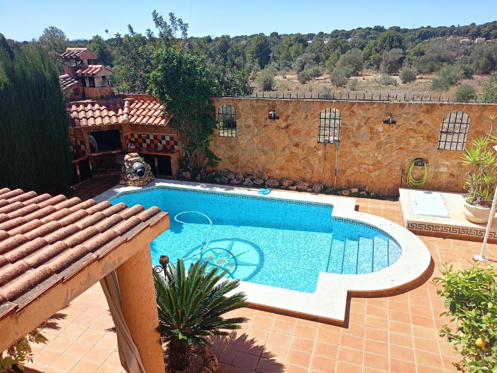 a swimming pool on a patio next to a building at chalet, villa rodeada de naturaleza con piscina cerca de la ciudad in Valencia