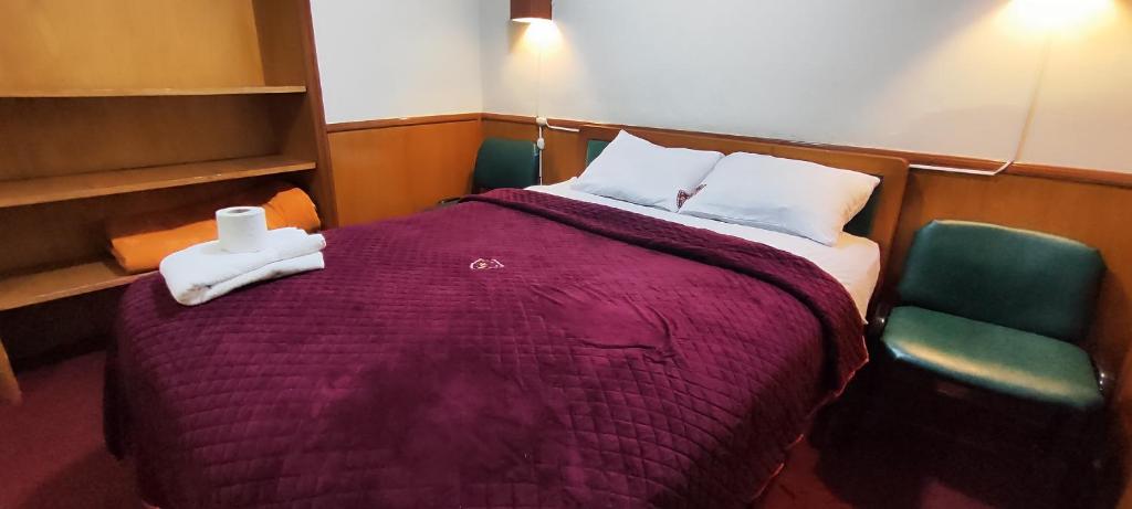 1 dormitorio con 1 cama grande y 2 sillas en Hotel Don Nelo, en La Paz