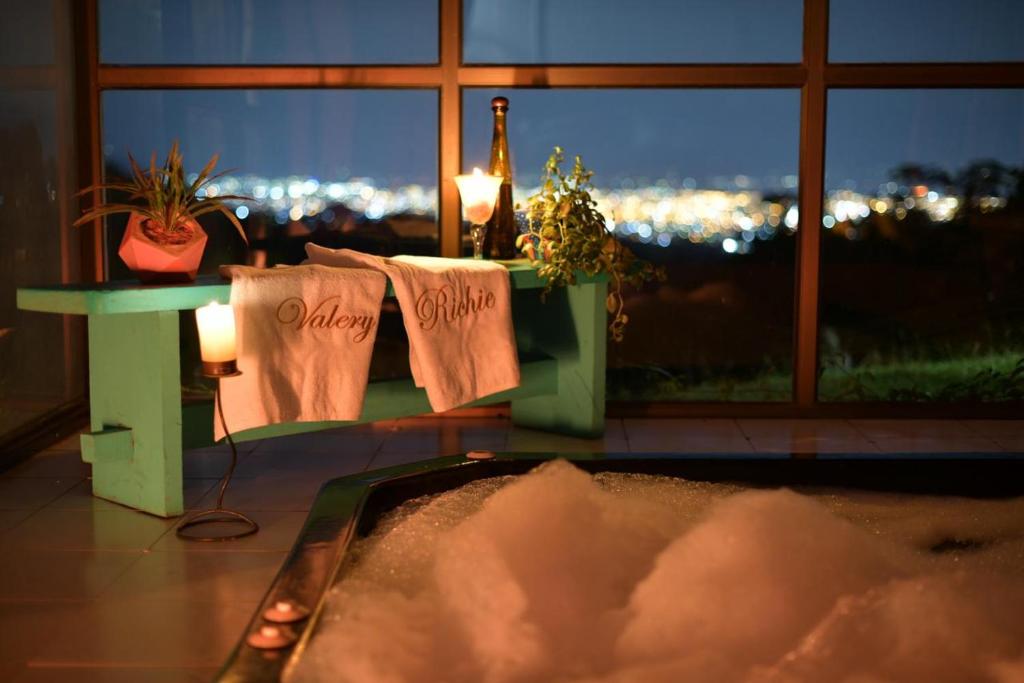 a bathroom with a view of a city at night at Habitacion The View in Cali