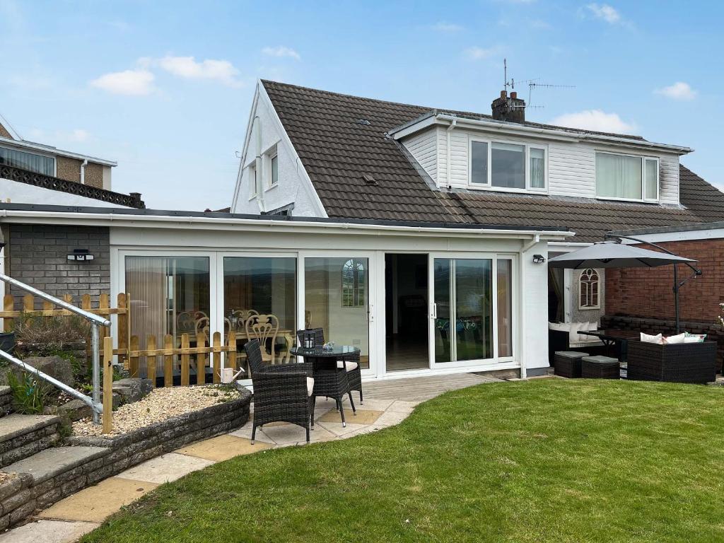a house with a patio with a table and chairs at Estuary Retreat in Llanelli