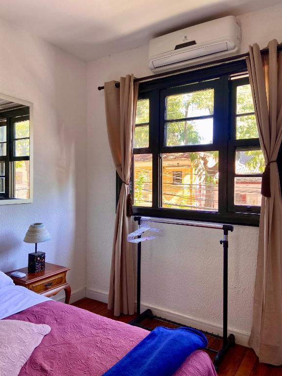 um quarto com uma cama e uma janela grande em Galeria SP Hostel em São Paulo