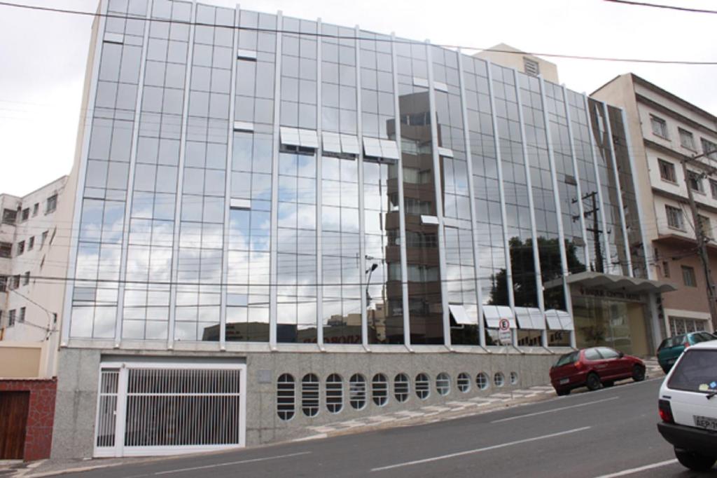 un gran edificio de cristal en una calle de la ciudad en Barbur Center Hotel en Ponta Grossa