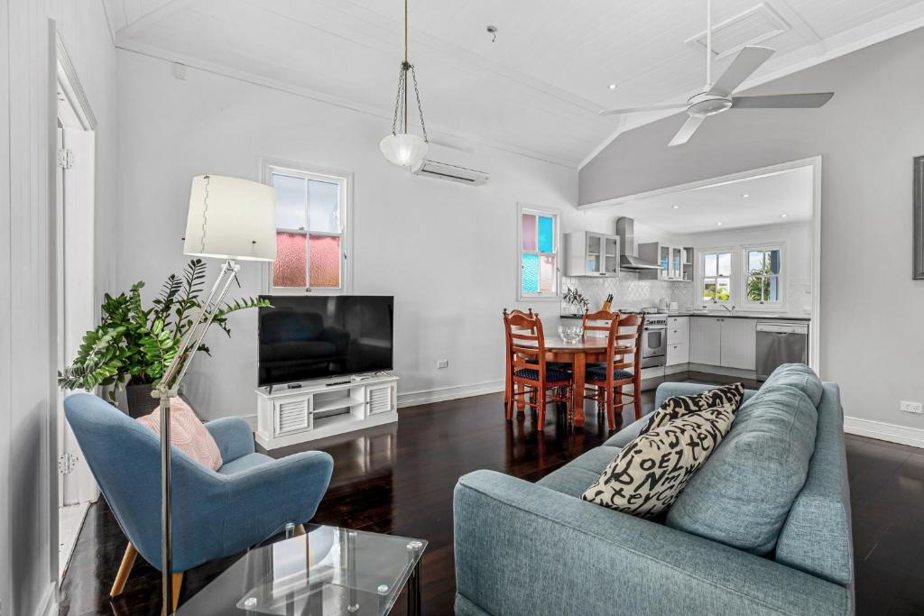 uma sala de estar com dois sofás azuis e uma cozinha em "Xanadu" Charming 2-Bed Retreat by Marcoola Beach em Bli Bli