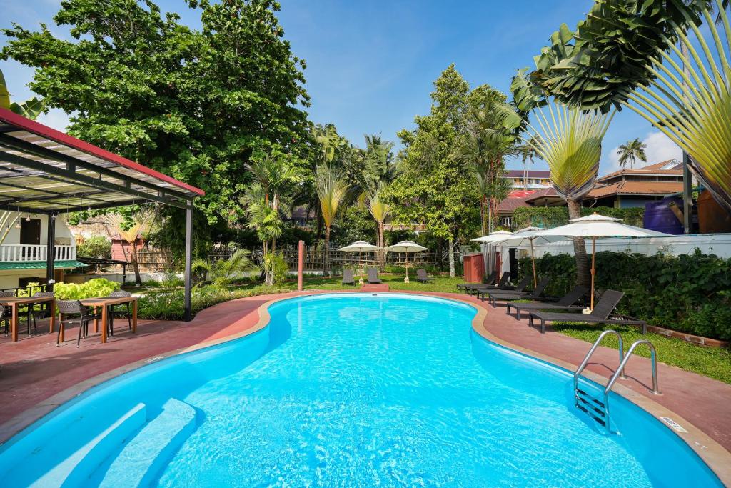 uma piscina num resort com mesas e guarda-sóis em Touch Sea Boutique Hotel&Bistro em Ka Rorn