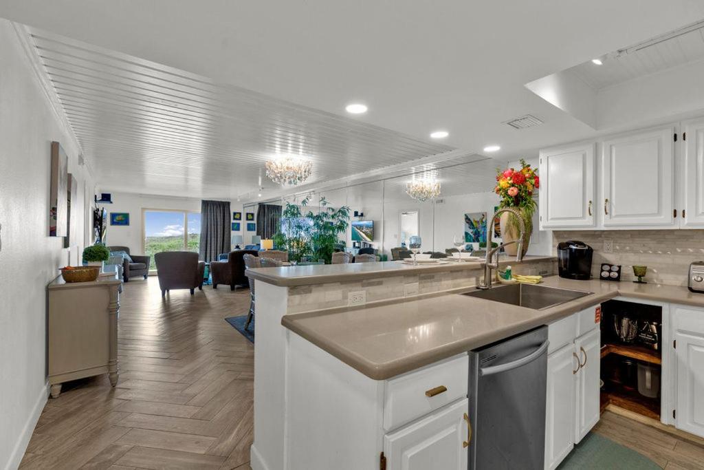 uma cozinha com armários brancos e um grande lavatório em Seagull Beachfront Condominiums em South Padre Island