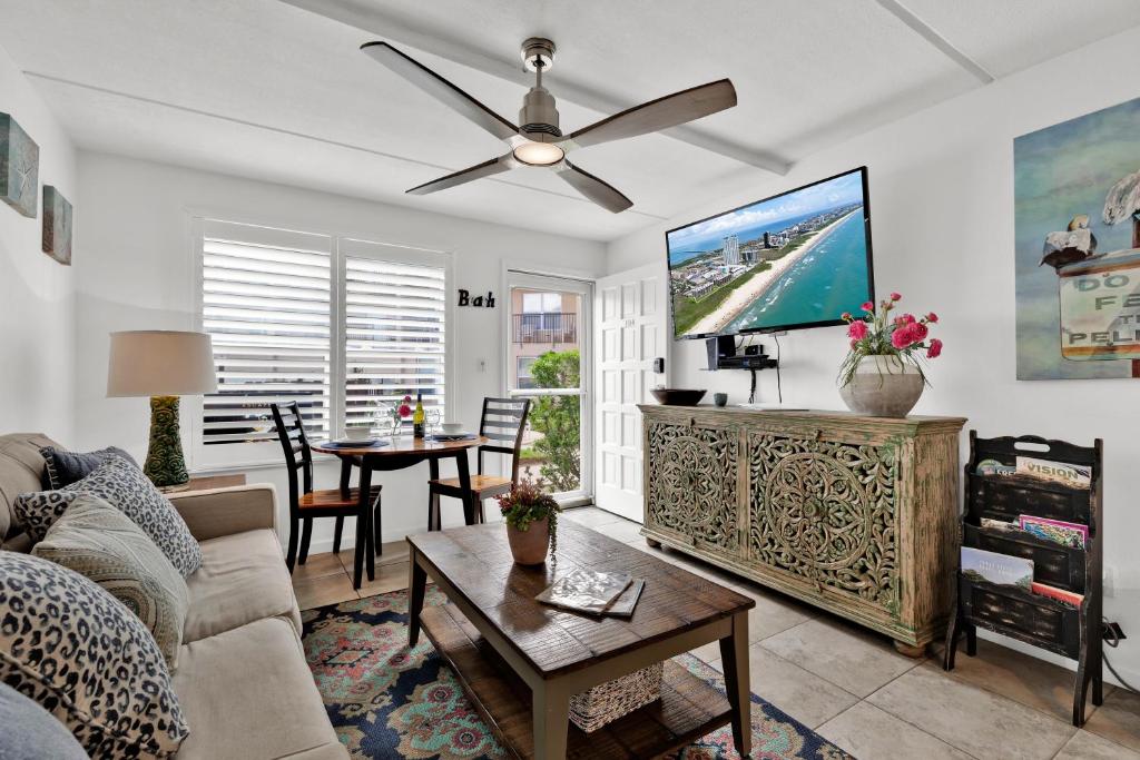 sala de estar con sofá y ventilador de techo en Beachside Bungalow: Surfside I #104, en South Padre Island