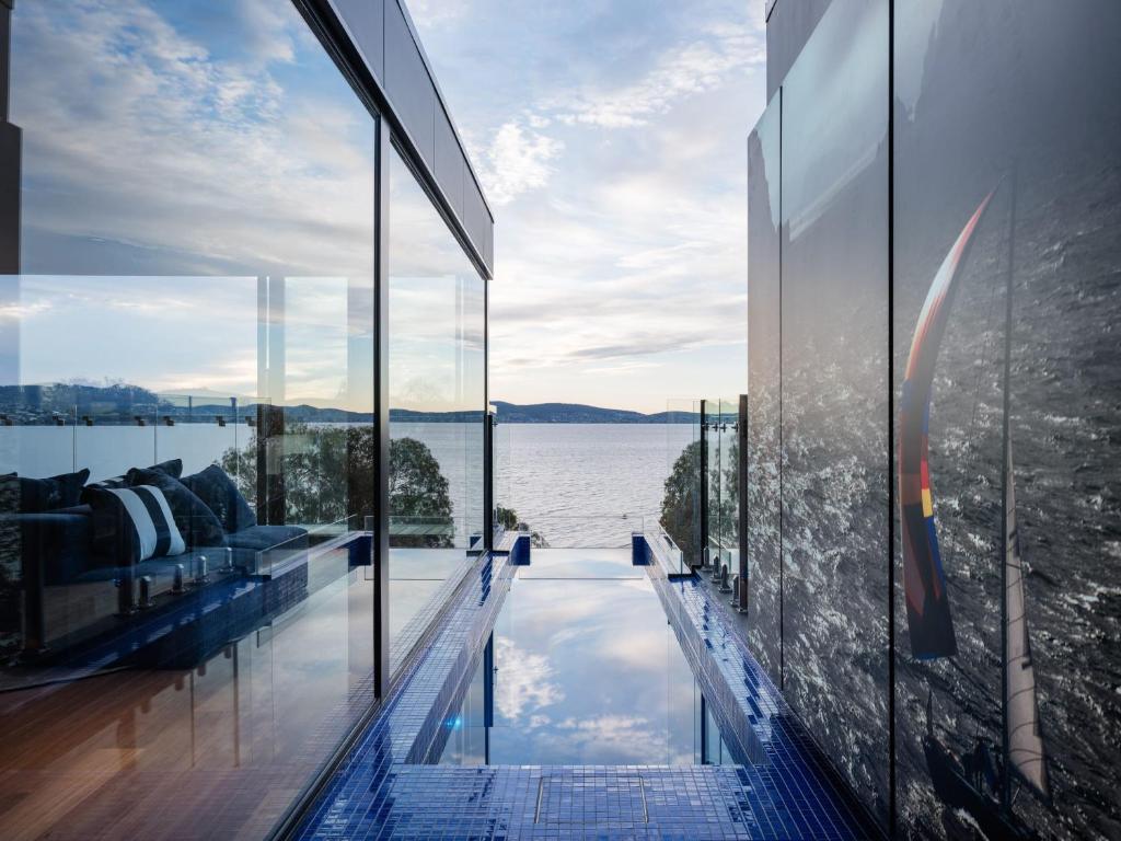 een huis met een zwembad met uitzicht op het water bij 'Hobart' - Waterfront penthouse with private heated pool in Hobart