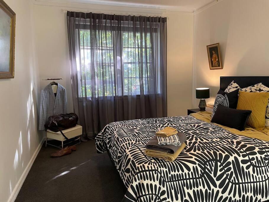 um quarto com uma cama em preto e branco e uma janela em Paris Chic in the CBD em Wagga Wagga