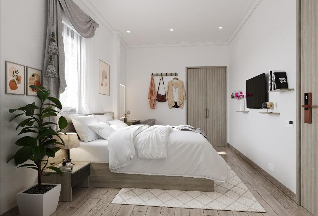 biała sypialnia z białym łóżkiem i rośliną w obiekcie Montcalm Hotel Saigon w Ho Chi Minh