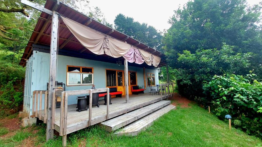 ein kleines Haus mit einer großen Terrasse im Hof in der Unterkunft Casa Monte Armadillo in Poás