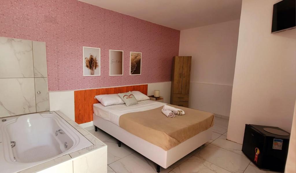 Schlafzimmer mit einem Bett und einer Badewanne in der Unterkunft Matianellu SP in São Paulo