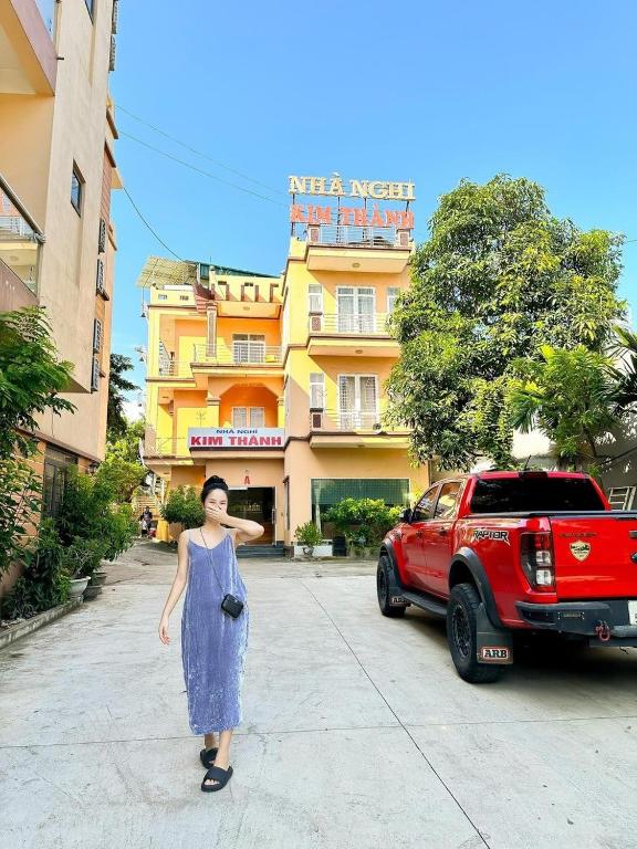 une femme debout dans une rue devant un bâtiment dans l'établissement Kim Thành Hotel - 718 Trần Thái Tông, TP Lào Cai - by Bay Luxury, à Lào Cai