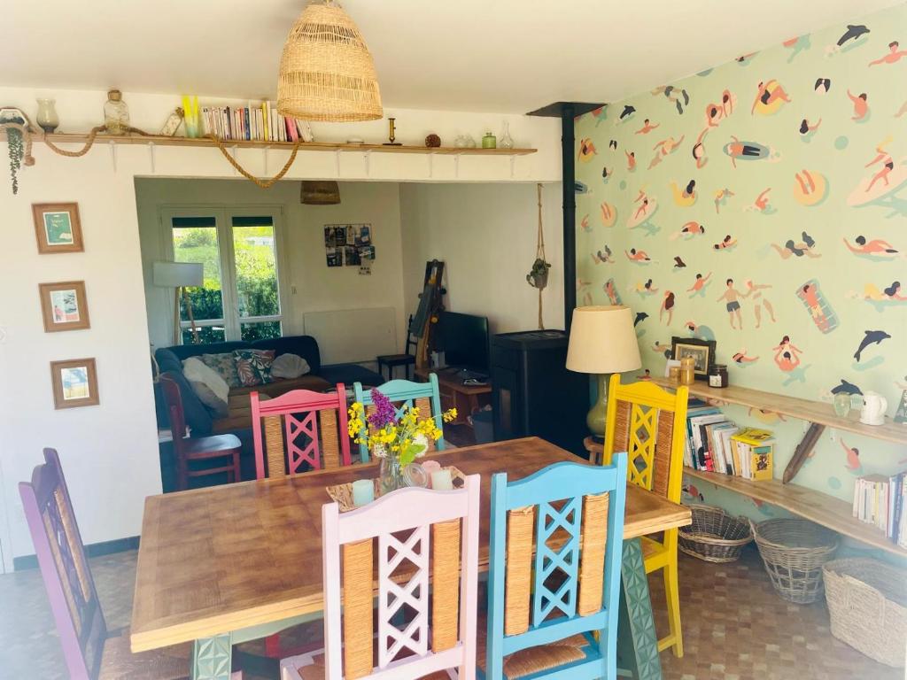 a dining room with colorful chairs and a table at La Maison du Temps Retrouvé à Wissant in Wissant