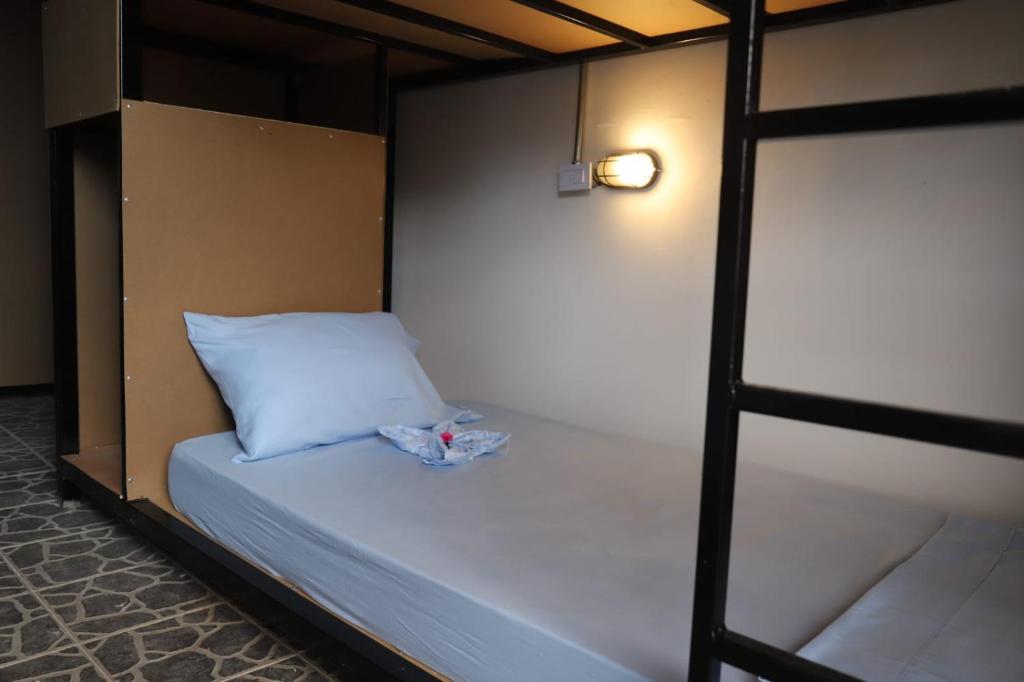 a bunk bed with a white pillow in a room at Asha Hostel in Fortuna